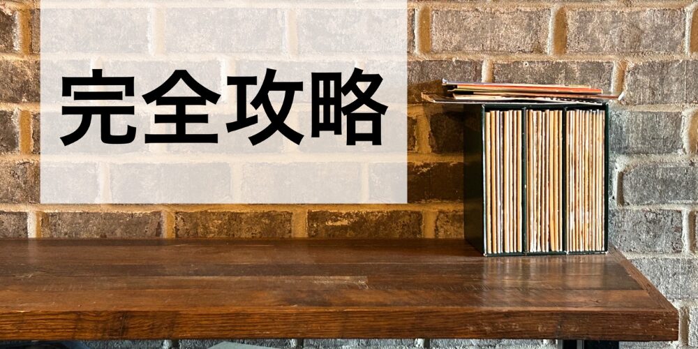 レンガ壁を背景に、木製テーブル上に並べられたレコードや本の背表紙。その上に半透明のボックスに黒字で『完全攻略』と書かれたイメージ