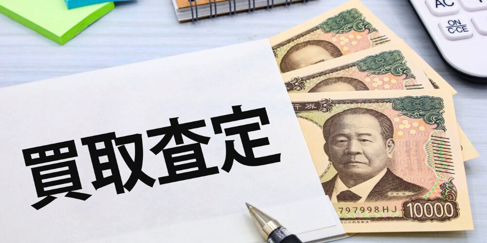 封筒から覗く一万円札とペン、封筒に『買取査定』と印字された書類のクローズアップ