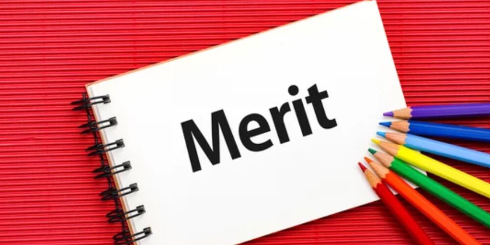 「Merit」と書かれたノートとカラフルな色鉛筆