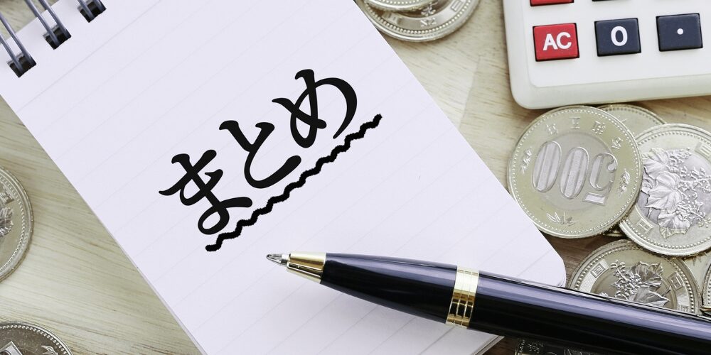 ノートに太字で下線付きの『まとめ』と書かれ、そばに置かれたボールペンと五百円硬貨、電卓が見えるデスク周りの様子