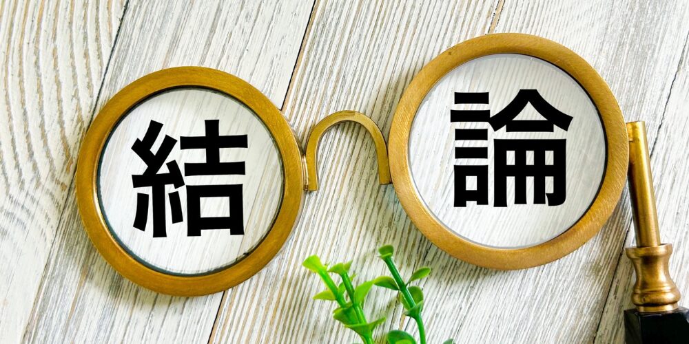 黒い計算機と金縁の拡大鏡越しに、木目調テーブルに並べられた植物の前で拡大鏡のレンズに『結論』と黒字で映し出されている様子